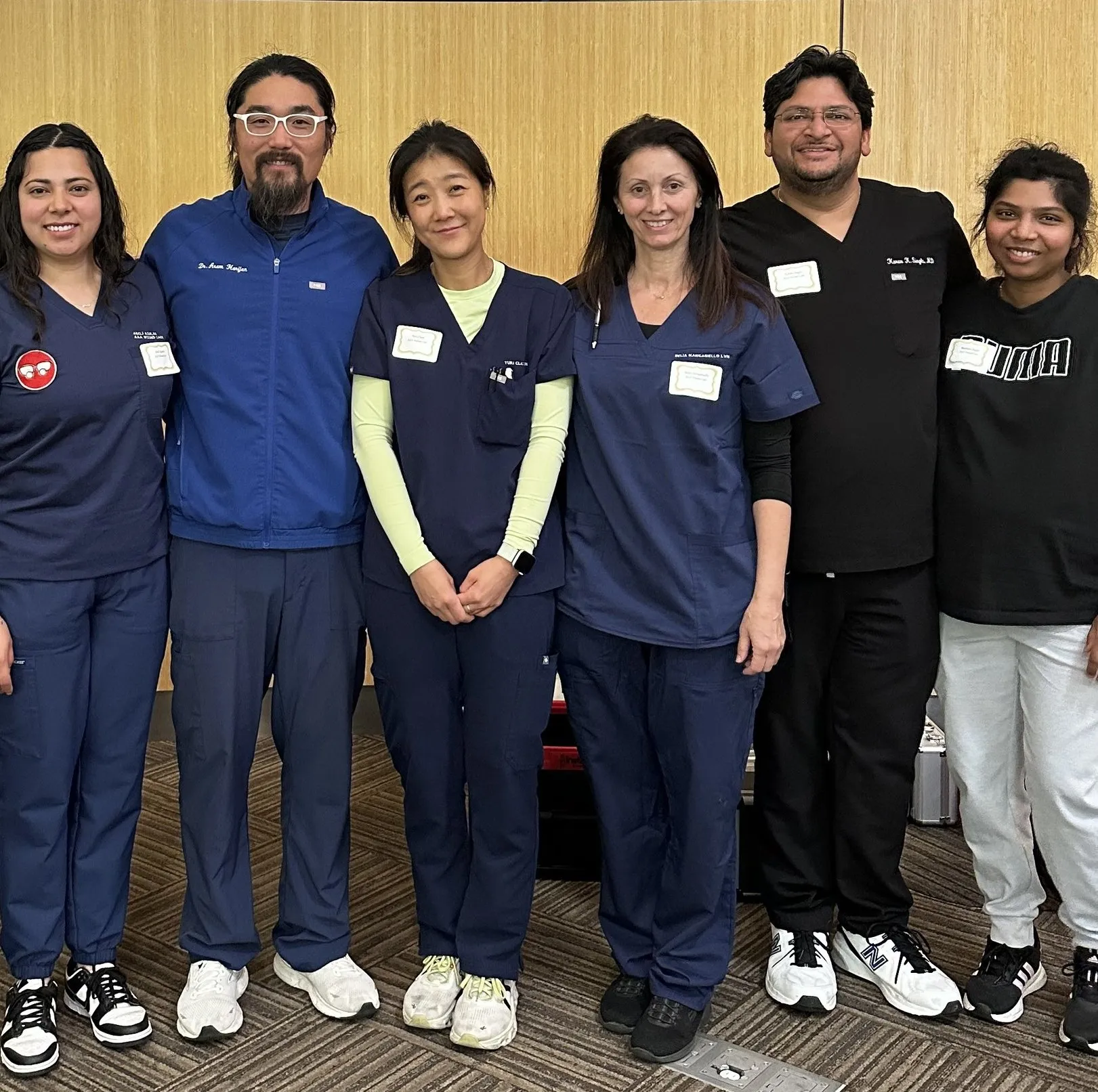 AAA Wound Care team members in scrubs standing together at the Street Medicine Initiative training in a conference room.