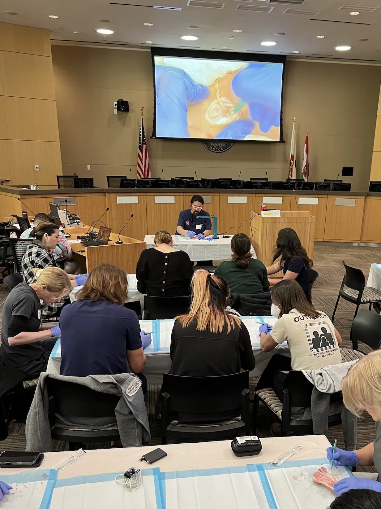 A group of people attending a medical workshop in a conference room.
